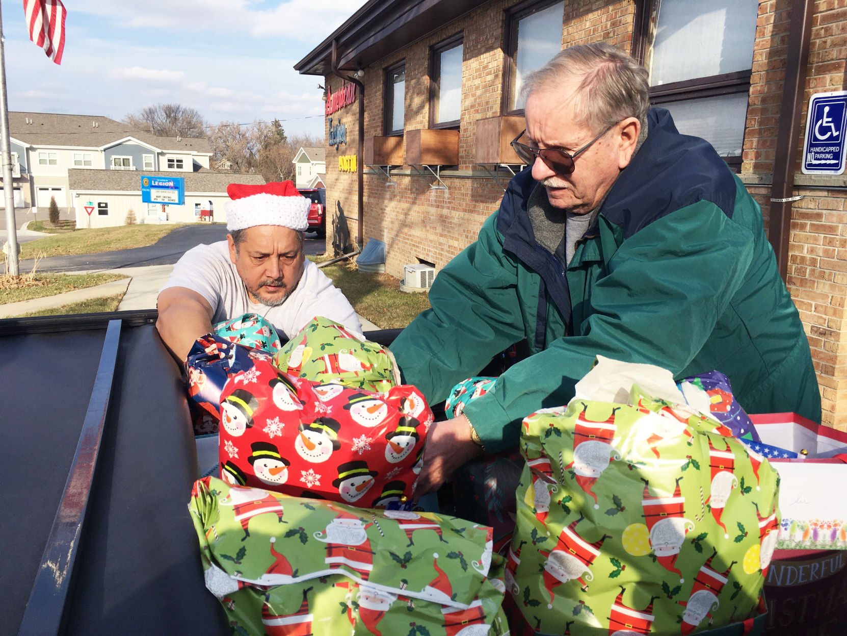 B. Shane Morris and Tom Busse load truck with holiday gifts for veterans home